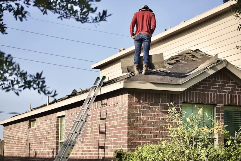Professional roofer working on a residential roof in Newtonville